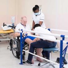 Two physios support wheelchair-bound man